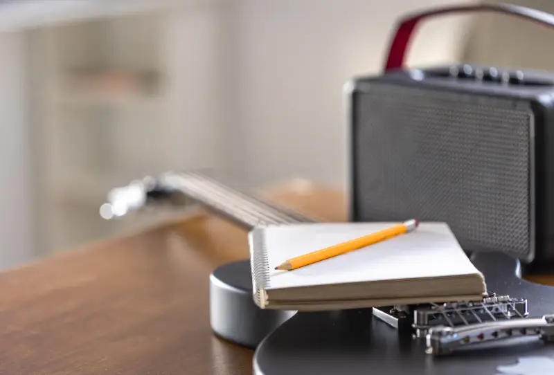 Black electric guitar notebook and speaker closeup